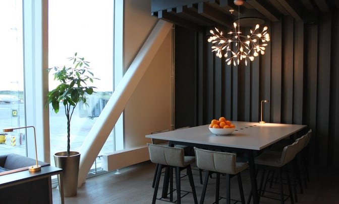 The North Sea Lounge at Stavanger Airport features a seating area with a high table, chairs, and a view of the tarmac.