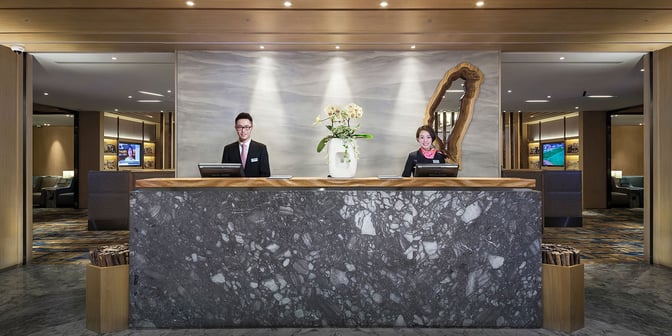 The reception area of Plaza Premium Lounge, Zone D at Taiwan Taoyuan International Airport, features a staffed check-in counter and seating area.