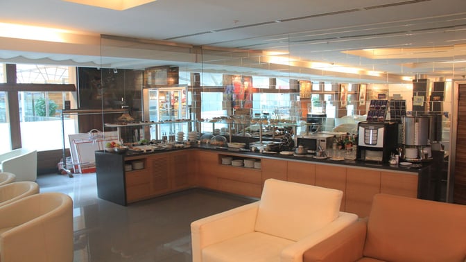 Self-serve food and beverage station at Primeclass CIP/VIP Lounge, Tbilisi International Airport, offers snacks, drinks, and seating.