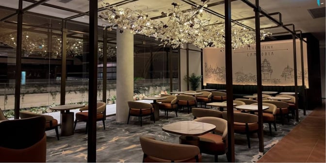 The seating area at Plaza Premium First Lounge in Techo International Airport features tables and chairs with views of the terminal.