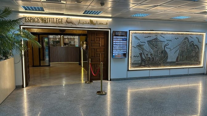 The Espace Privilege Lounge entrance at Tunis–Carthage Airport features a reception area and a decorative wall mosaic.