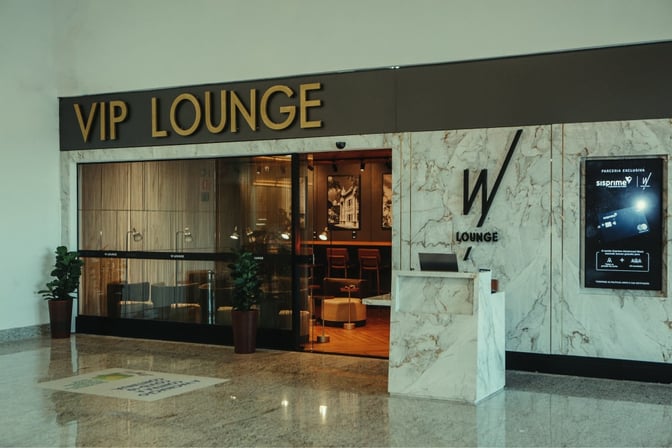 The W Lounge entrance at Uberlândia Airport features a reception desk and visible seating area, located near the departure gates.