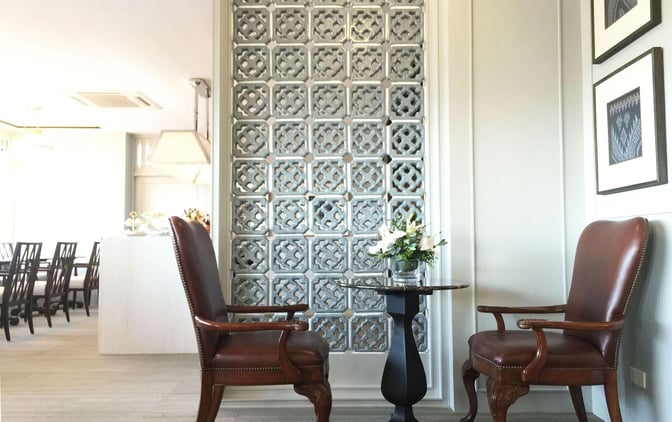 A seating area in The Coral Executive Lounge at Udon Thani International Airport features armchairs and a small table with floral decor.