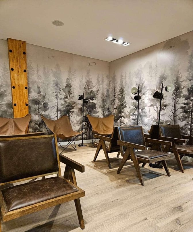 The seating area in W Lounge Ushuaia features leather chairs and floor lamps, providing a comfortable space for travelers to relax.