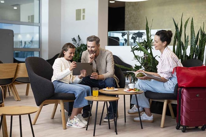 Seating area in Prague's Fast Track Lounge features comfortable chairs and tables with snacks and drinks available for travelers.