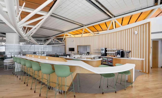 The SkyTeam Lounge at Vancouver International Airport features a self-serve food and beverage area with counter seating and refreshments.