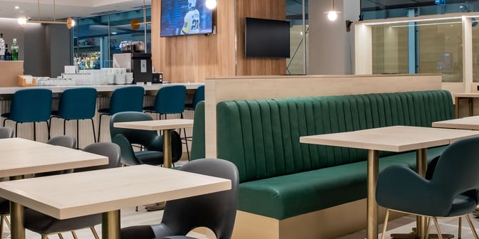 The Plaza Premium First lounge at Vancouver International Airport features a bar with counter seating and a dining area with booth seating.
