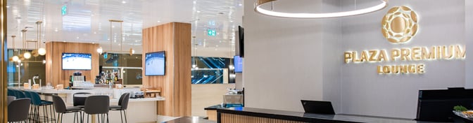 The Plaza Premium Lounge at Vancouver International Airport features a bar area with seating, televisions, and a variety of beverages.