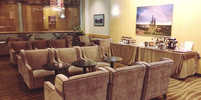 The seating area in Plaza Premium Lounge at Vancouver International Airport features comfortable chairs and a self-serve beverage station.