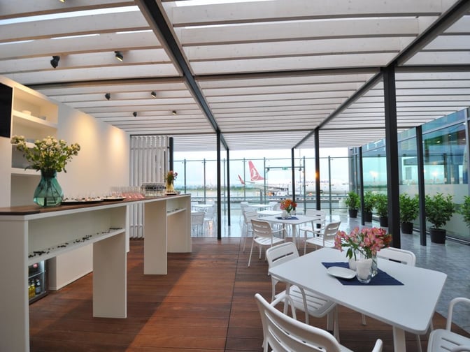 The VIP lounge at Varna Airport features a seating area with tables and chairs, offering views of the tarmac.