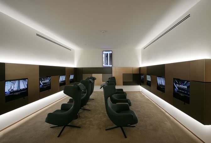 The Marco Polo Club lounge at Venice Airport features a media room with individual screens and comfortable seating for travelers.