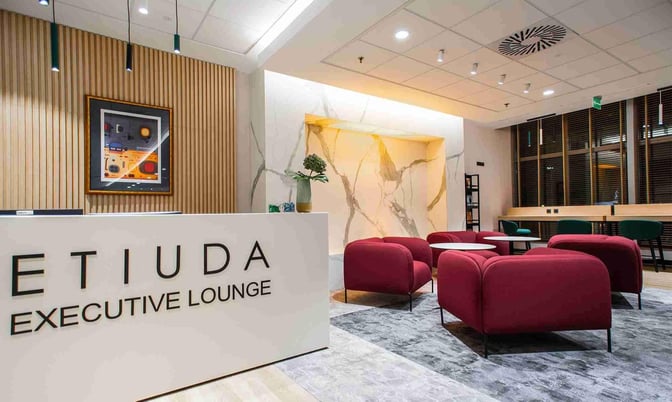 The Etiuda Executive Lounge at Warsaw Chopin Airport features a reception desk and comfortable seating area for travelers.