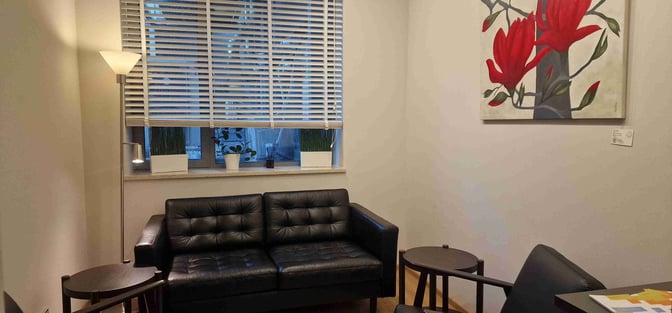 The seating area in Mazovia Premium Lounge features a sofa, side tables, and a floor lamp, providing a comfortable waiting space.