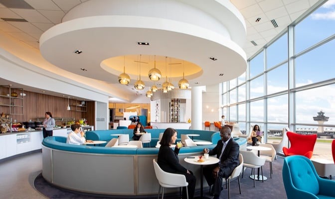 The Air France/KLM Lounge at Washington Dulles features circular seating with tables, offering views of the airport through large windows.