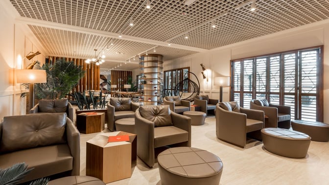 The Primeclass Lounge at Zagreb Airport features comfortable seating with armchairs and tables, providing a relaxing space for travelers.
