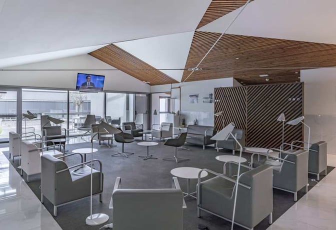 The VIP Lounge at A Coruña Airport features seating areas with armchairs, small tables, and a television for passenger comfort.
