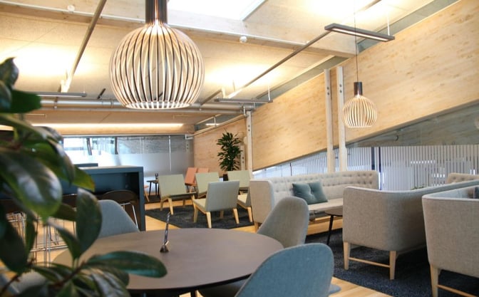 The Aalborg Airport Lounge features various seating options, including sofas and chairs, providing a comfortable space for travelers to relax.