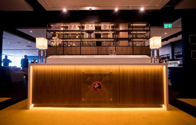 The Northern Lights Executive Lounge at Aberdeen Airport features a bar with a selection of spirits and illuminated counter.