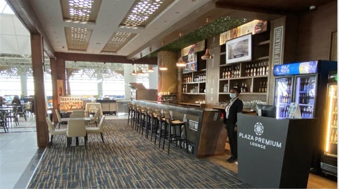The Plaza Premium Lounge at Addis Ababa Bole International Airport features a bar area with counter seating and a variety of beverages.