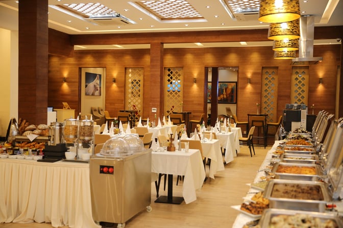 The dining area at Plaza Premium Lounge in Addis Ababa Bole International Airport features buffet stations and table seating for guests.