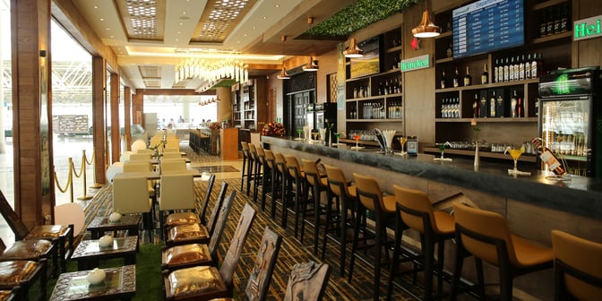 The Plaza Premium Lounge at Addis Ababa Bole International Airport features a bar with high seating and a variety of beverages.