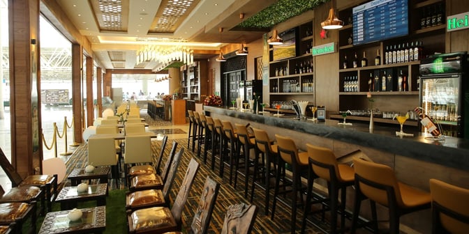 The Plaza Premium Lounge at Addis Ababa Bole International Airport features a bar with high seating and a variety of beverages.