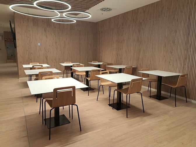 The dining area in the Retiro VIP Lounge at Madrid Barajas Airport features multiple tables with chairs for seating.