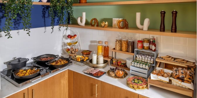 The Hub at Madrid Barajas Airport offers a self-serve breakfast station with hot dishes, cereals, fruits, and beverages.