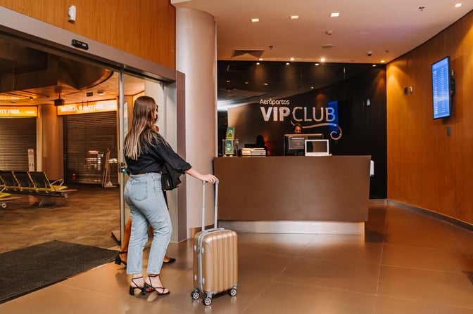 The Aeroportos VIP Club entrance at Brasilia International Airport features a reception desk and is located near the duty-free area.