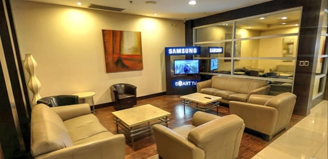 Seating area in the Aeroportos VIP Club at José Joaquín de Olmedo International Airport features sofas and a television for relaxation.