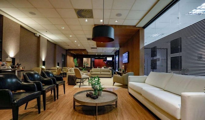 The Break Travel Lounge at Afonso Pena International Airport features a seating area with various chairs and sofas for relaxation.