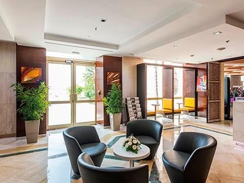 The Agadir Aspire Executive Lounge features a seating area with armchairs around a central table near the entrance.