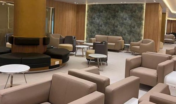 The seating area in Ahlein - Emerald Lounge at Cairo International Airport features various armchairs and small tables for passenger comfort.