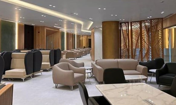 The seating area in Ahlein - Emerald Lounge at Cairo International Airport features various armchairs and sofas with semi-private sections.