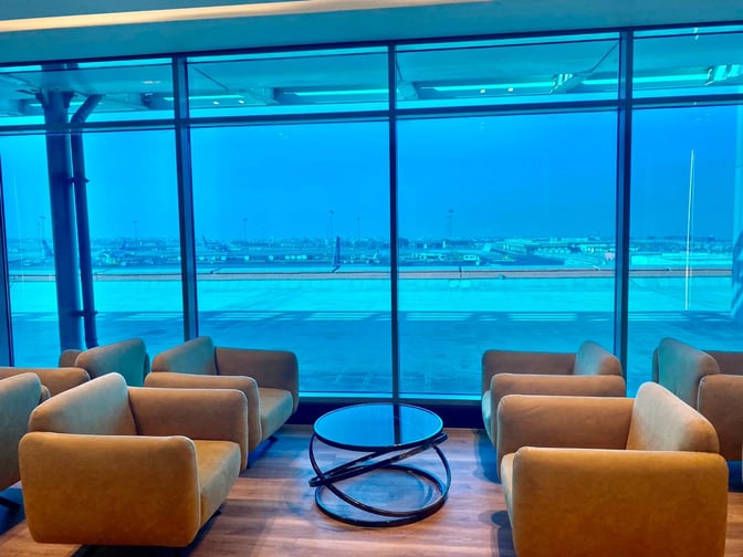 Seating in the Ahlein Premium Lounge at Cairo International Airport offers views of the tarmac through large windows.