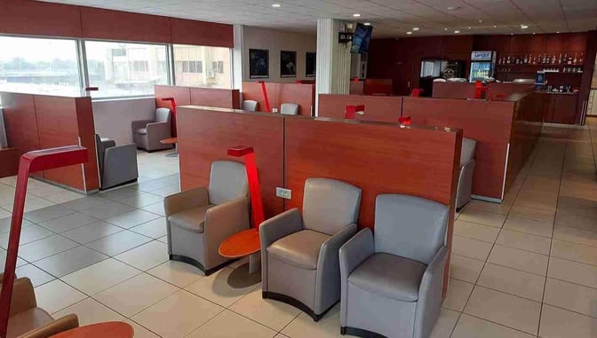 The Air France Lounge at Douala International Airport features partitioned seating areas with armchairs and small tables for passenger comfort.