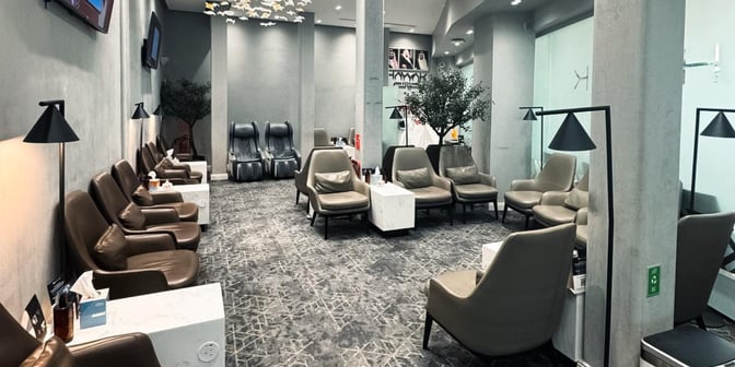 The seating area in Hayyak Lounge at King Saud Domestic Airport features comfortable chairs, individual tables, and massage chairs for relaxation.