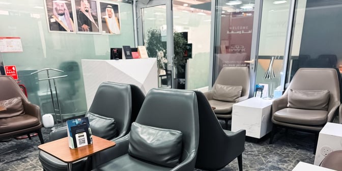 The seating area in Hayyak Lounge at Al-Jouf International Airport features comfortable chairs with side tables and charging outlets.