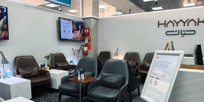 The Hayyak Lounge at Al-Jouf International Airport features comfortable seating with individual tables and lamps, providing a relaxing waiting area.