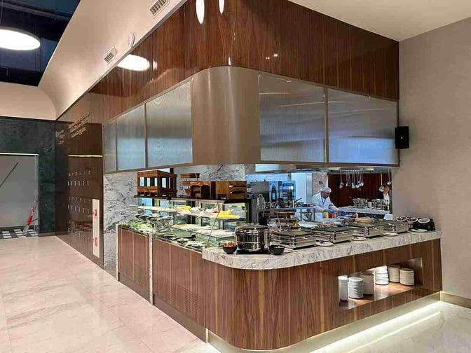 The Extime Business Lounge at Almaty International Airport features a self-serve food area with a variety of hot and cold dishes.