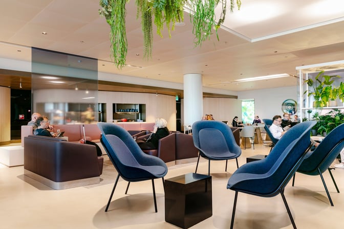 The Aspire Lounge at Amsterdam Schiphol Airport features a seating area with comfortable chairs and tables, accommodating travelers near Gate 26.