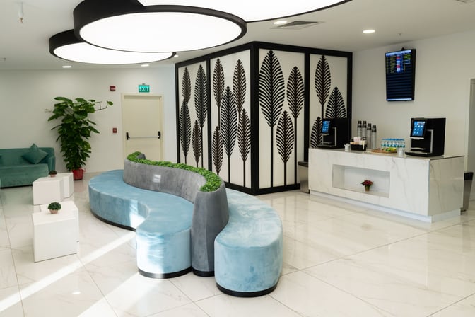 The CIP Lounge at Antalya Airport features a seating area with curved benches and a refreshment station offering beverages and snacks.