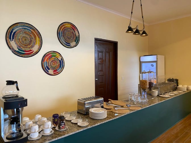 The Kilimeru Lounge at Arusha Airport features a self-serve breakfast area with coffee, cereal dispensers, and a toaster.