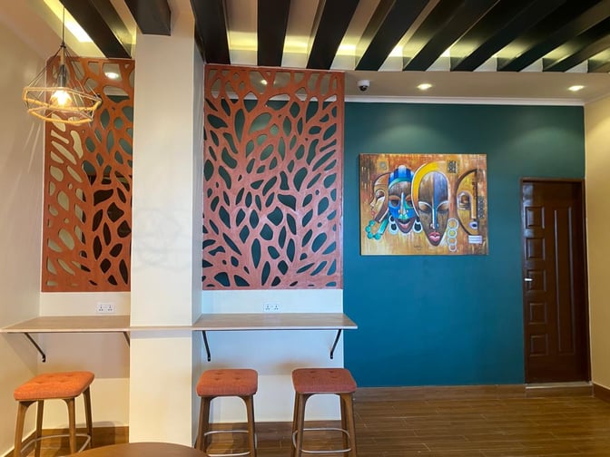 The Kilimeru Lounge at Arusha Airport features a seating area with stools and a decorative partition, alongside wall art.