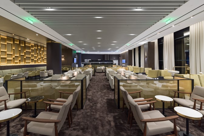 The seating area in Goldair Handling Lounge, Hall A at Athens International Airport features armchairs and small tables arranged for passenger comfort.