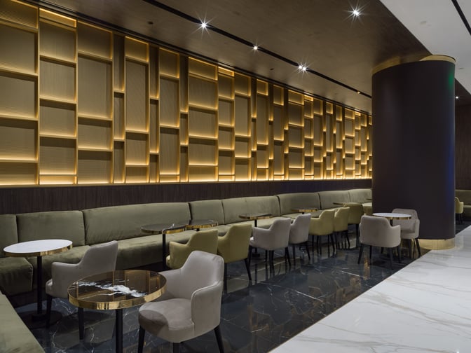 The seating area in Goldair Handling Lounge, Hall A at Athens Airport features cushioned chairs and tables for passenger comfort.