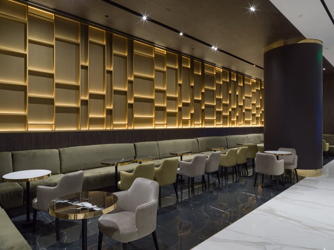 The seating area in Goldair Handling Lounge, Hall A at Athens Airport features cushioned chairs and tables for passenger comfort.