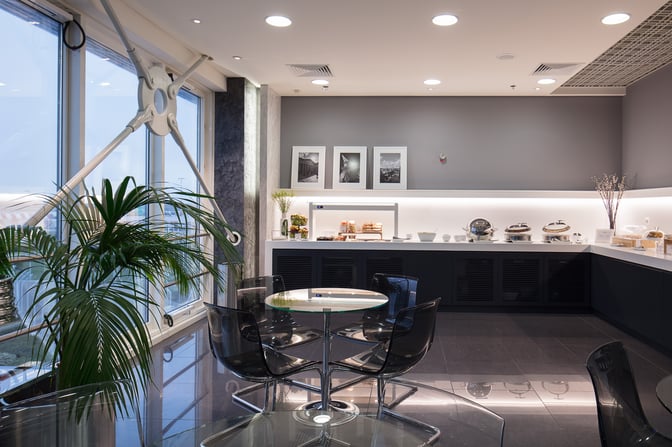 The Goldair Handling CIP Lounge at Athens International Airport features a self-serve food area with tables and chairs for dining.