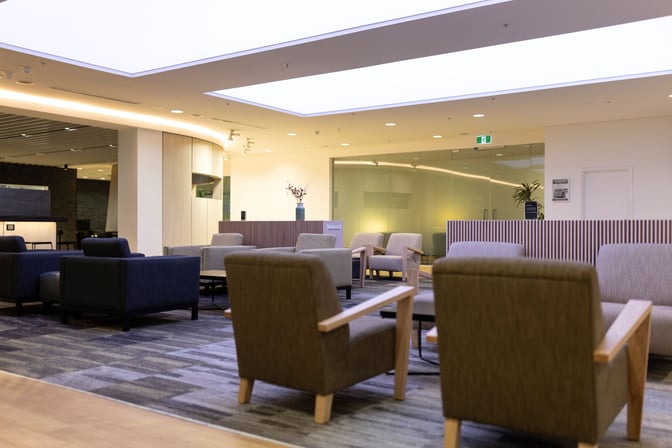 The seating area in Strata Lounge at Auckland Airport features comfortable armchairs and tables, providing a relaxing space for travelers.