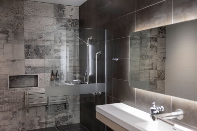 The shower area in Strata Lounge at Auckland Airport features a glass enclosure, wall-mounted toiletries, and a modern sink.